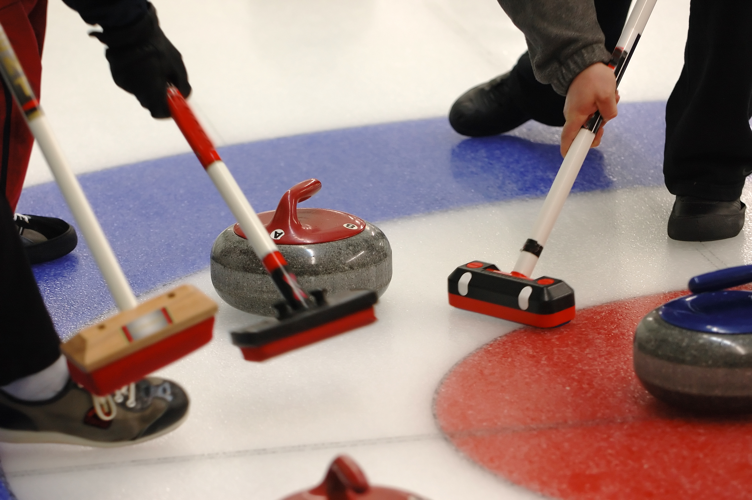 Curling Actie met vegers en steen