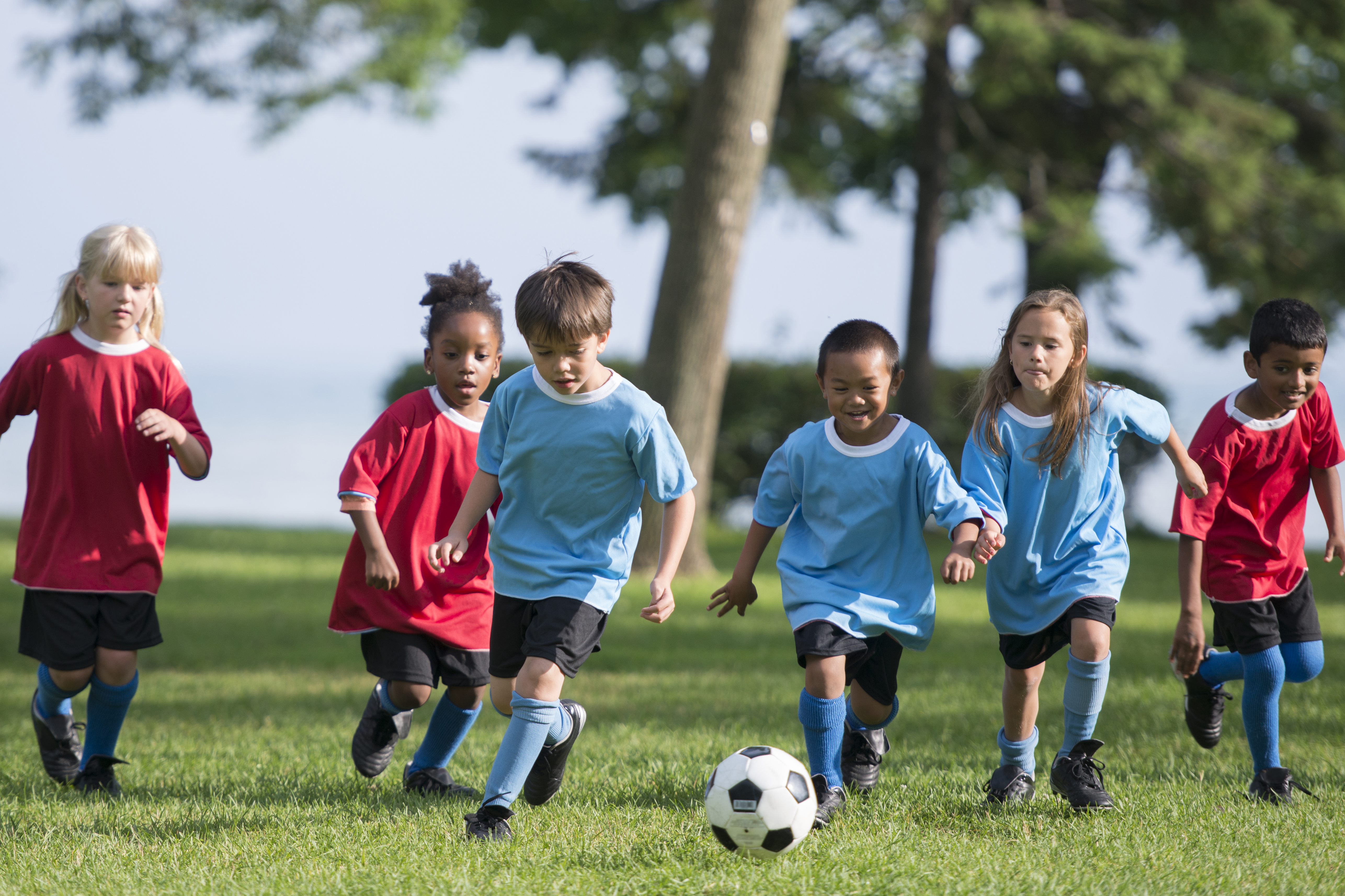 Multiculturele groep kindjes spelen voetbal