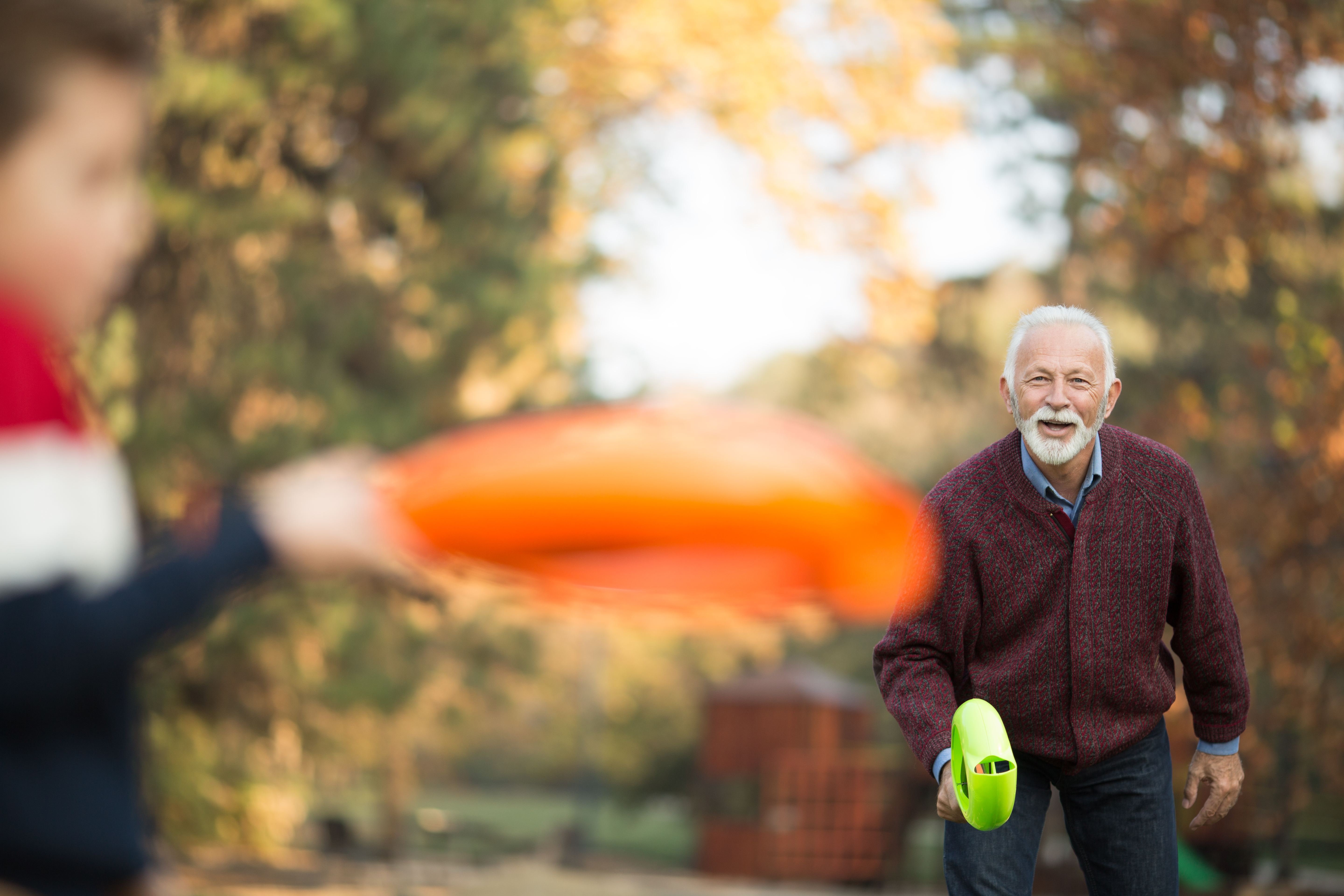 Photo of a grandfather playing with grandson outdoors