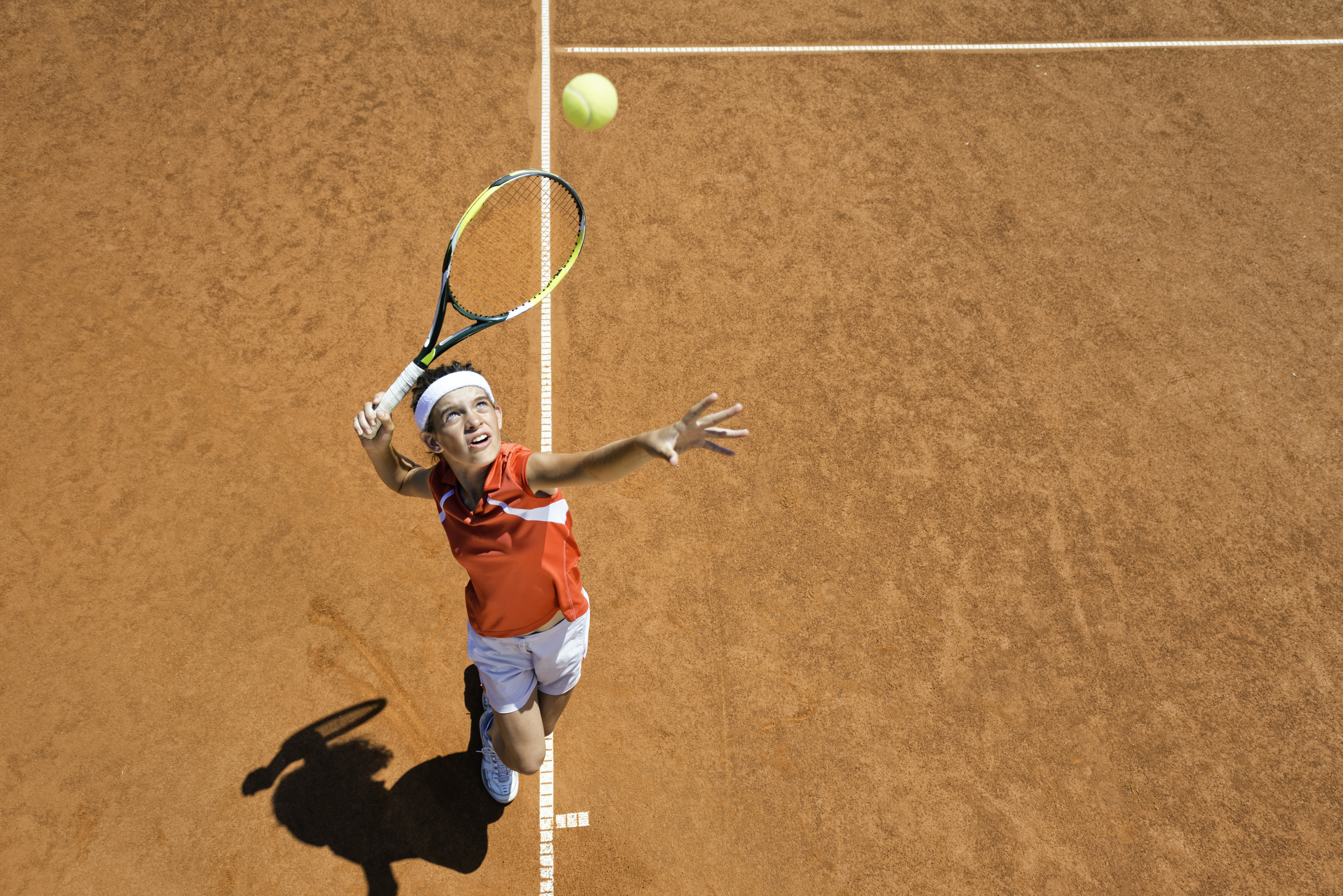 Jongen slaat op met tennisracket