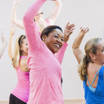 Multi-culturele groep dames dansen met handen in de lucht