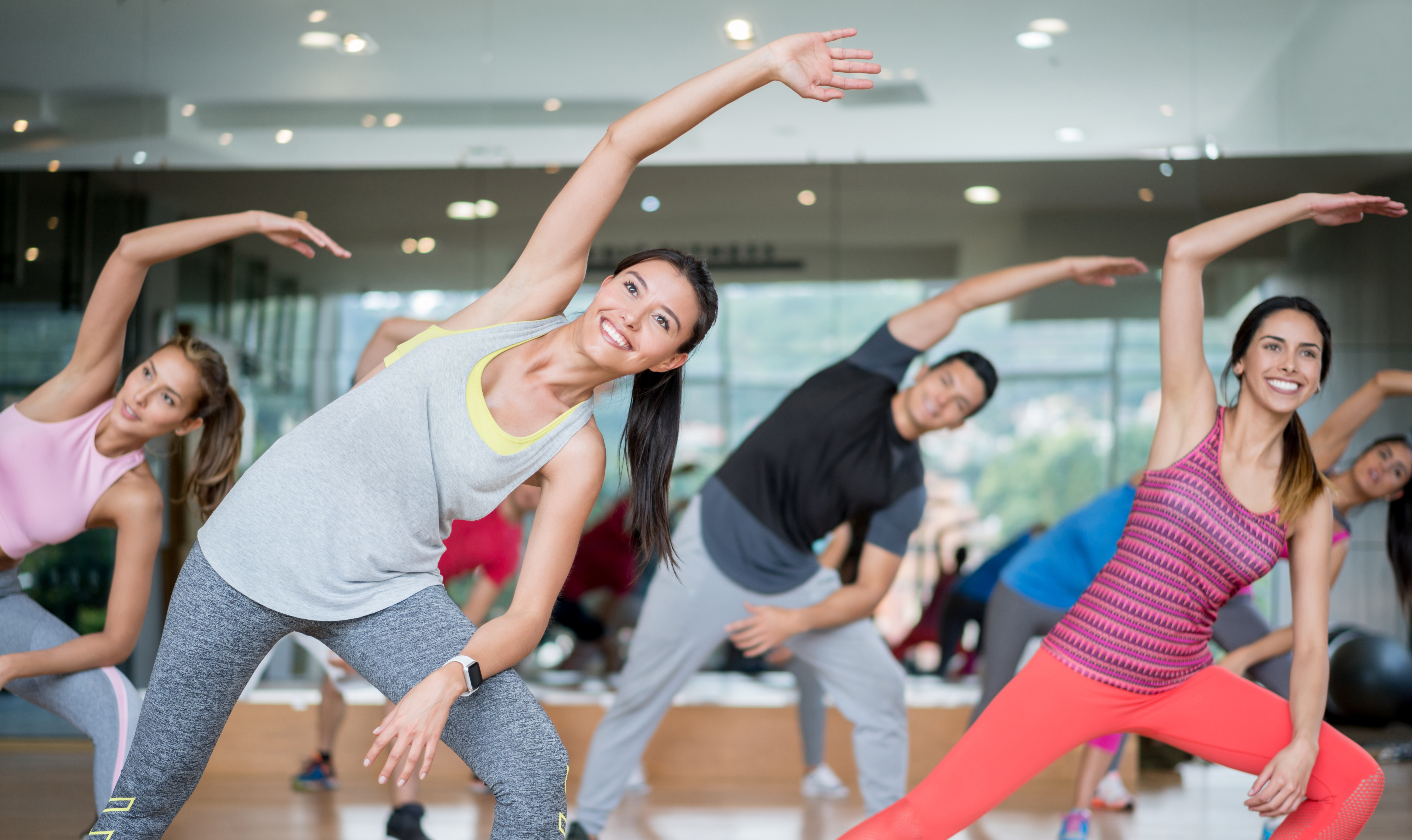 Gemengde groep jonge mensen stretchen tijdens aerobics
