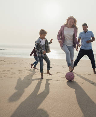 Gezin voetbalt op strand