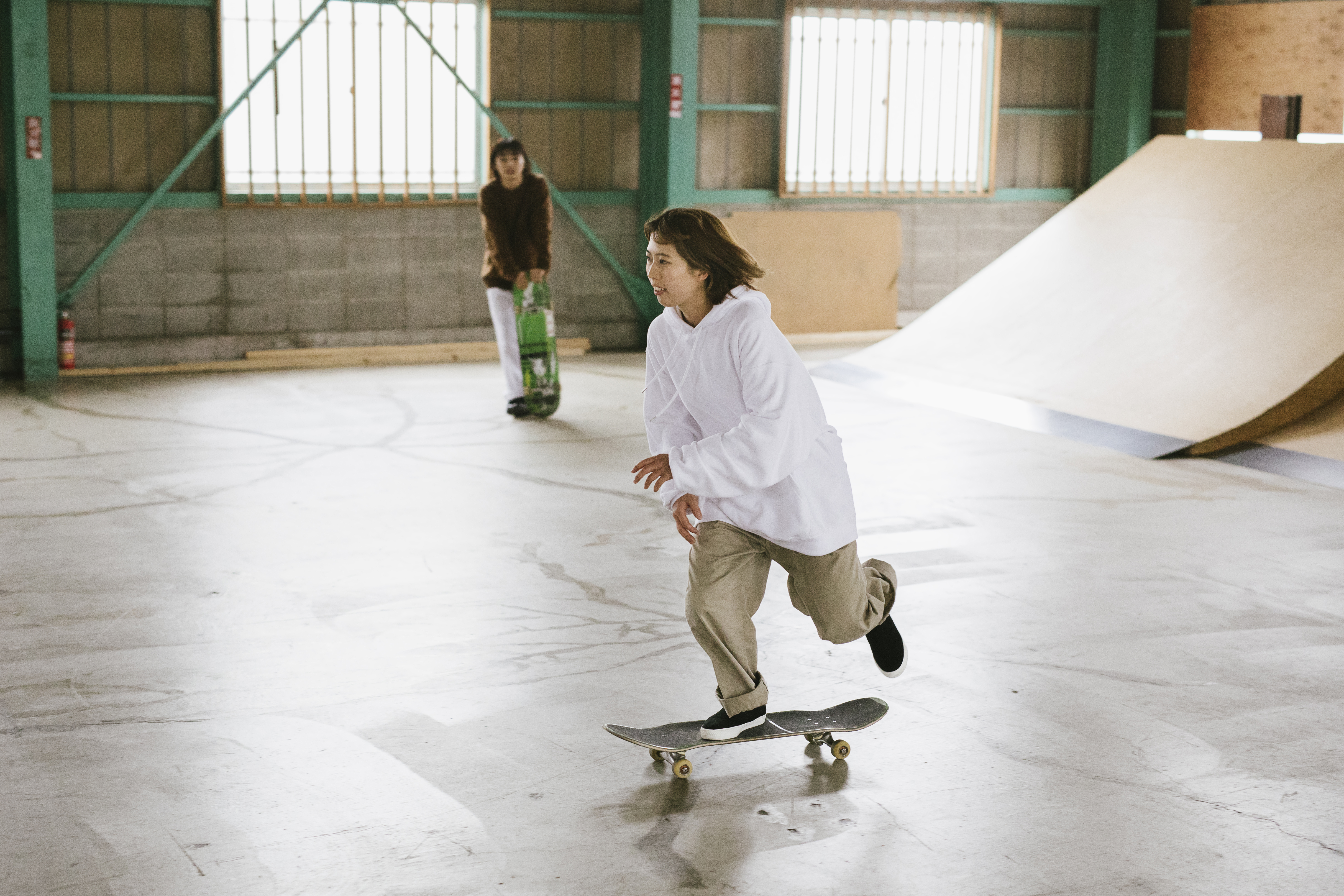 Meisje rijdt met skateboard op overdekte piste