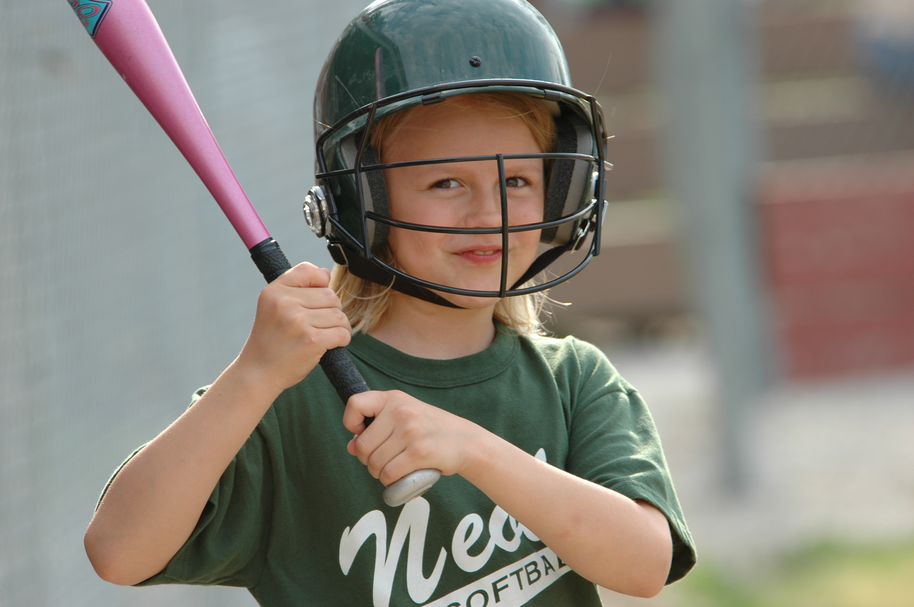 Jonge baseballspeelster wacht om op baseballbal te slaan