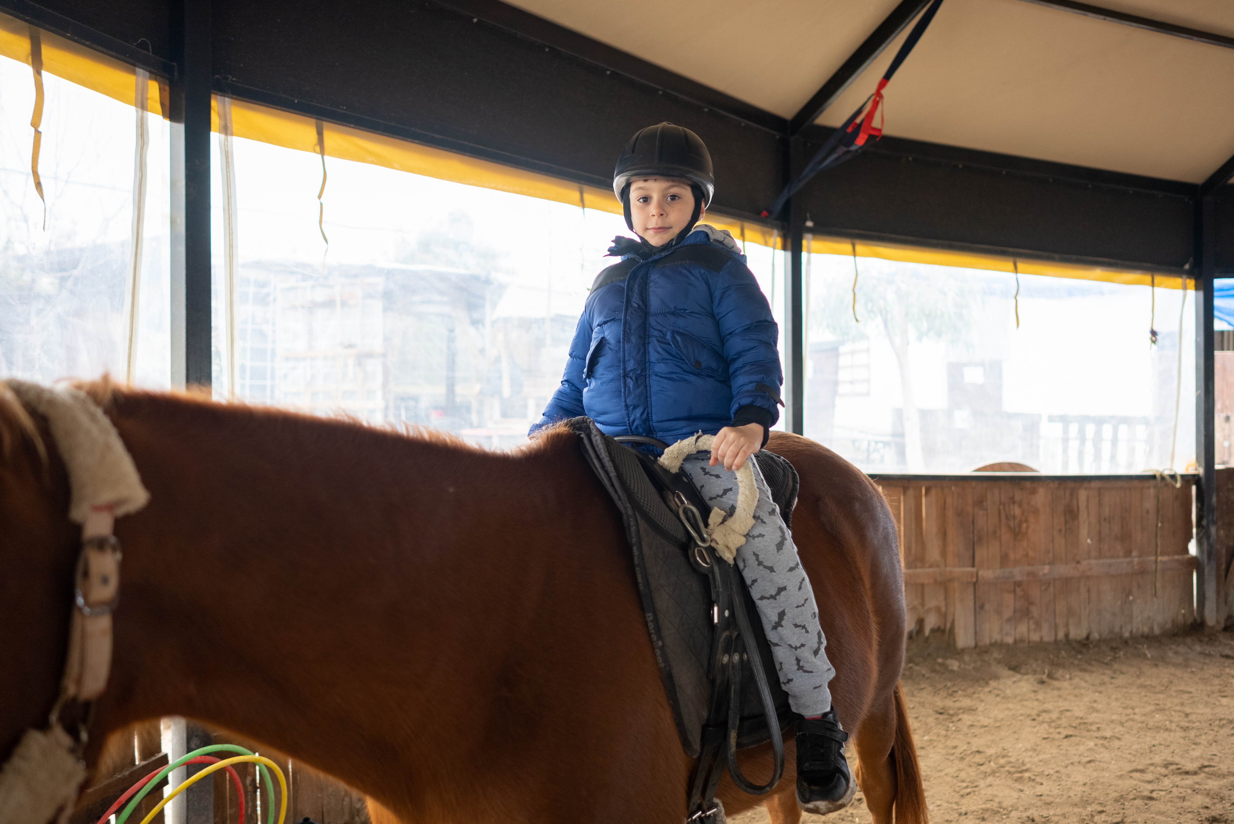 Little boy riding training horse
