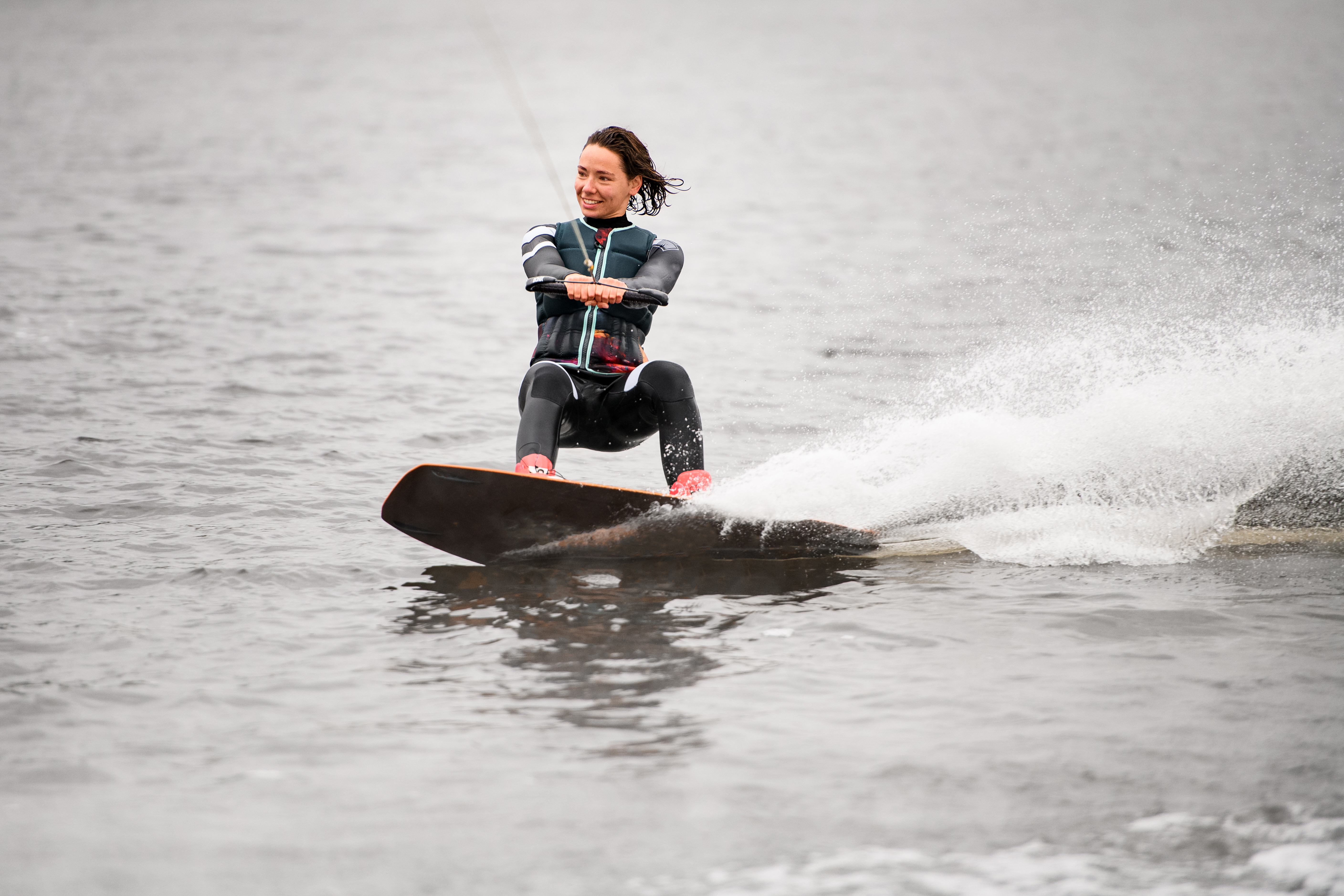 Vrouw aan touw op waterskilatten