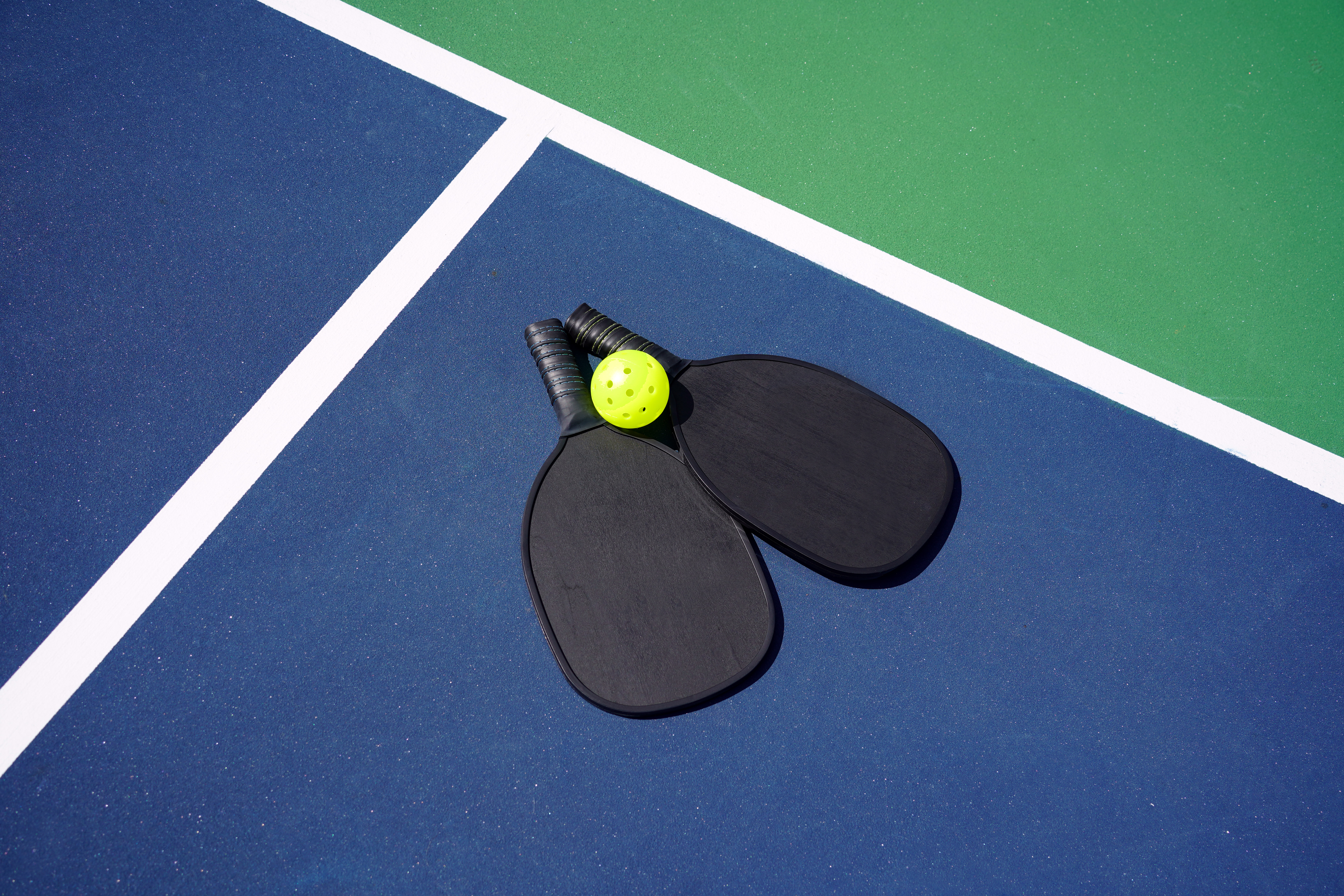 Twee Pickleball paddles en een wifflebal