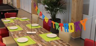 Cafetaria met gedekte feesttafel voor de verjaardagsfeestjes