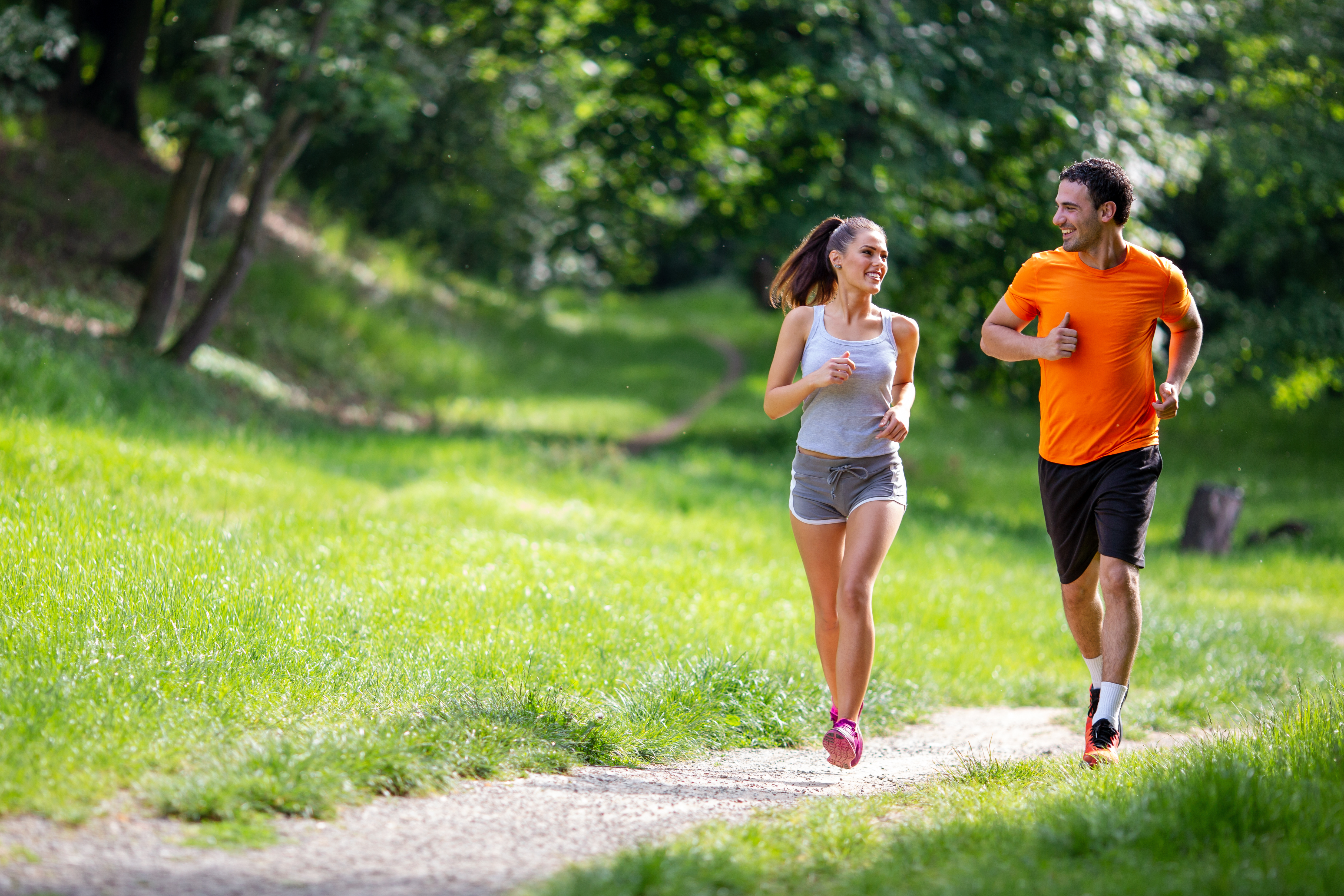 Portrait of happy young fit people running together ourdoors. Couple sport healthy lifetsyle concept