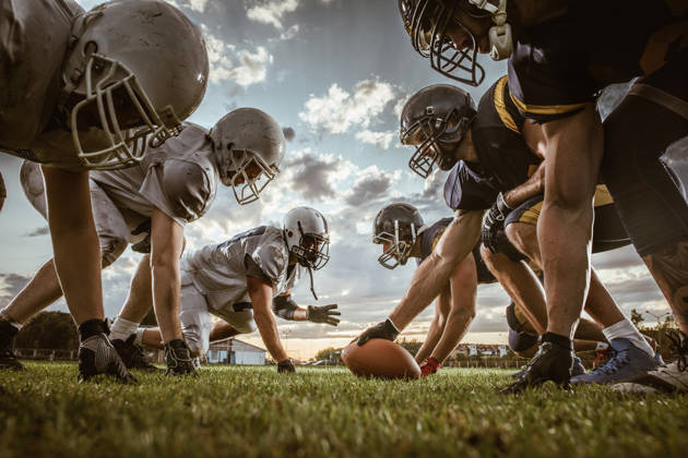 American football spelers tegenover elkaar bij het begin van de match