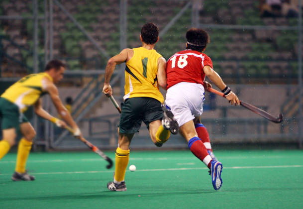 Drie hockeyspelers vechten om bal